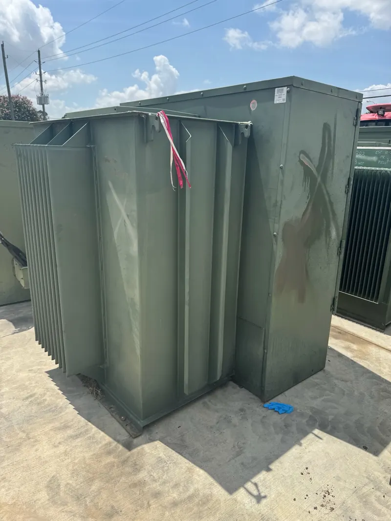 Close view of a green surplus liquid-filled transformer outdoors before evaluation