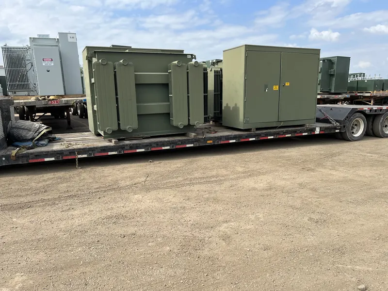 Multiple liquid-filled and pad-mounted electrical transformers secured on a flatbed trailer